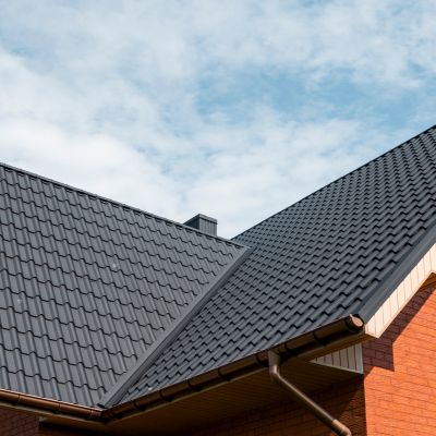Modern roof covered with tile effect PVC coated brown metal roof sheets.